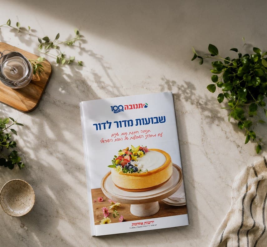 The Tnuva Shavuot cookbook open on a marble counter, a recipe spread facing up